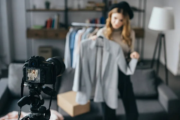 Sonriente blogger de moda grabando un nuevo vlog sobre chaqueta con cámara en primer plano - foto de stock