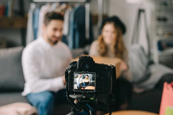 Fashion bloggers sitting with box in front of camera — Stock Photo