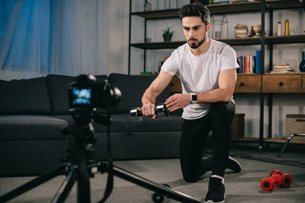 Serious sport blogger showing how to train with dumbbells — Stock Photo