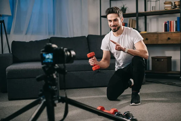 Smiling sport blogger recording new blog about dumbbells — Stock Photo