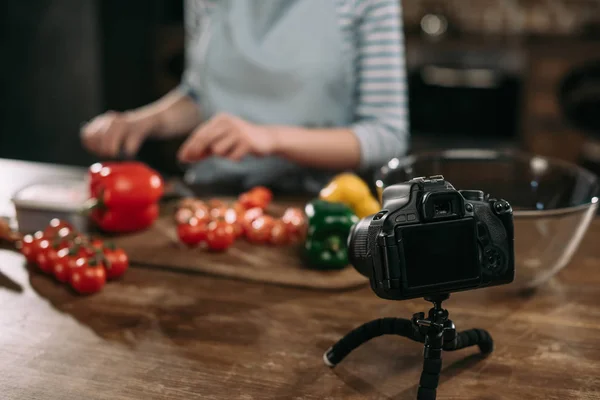 Imagen recortada del bloguero de alimentos preparando comida en una mesa de madera - foto de stock