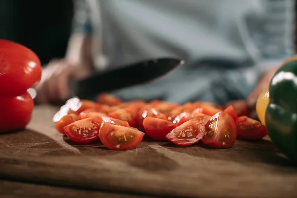Imagem cortada de cozinhar o corte de tomates cereja em tábua de madeira — Fotografia de Stock