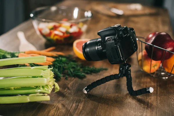 Digitalkamera und Gemüse auf Holztischplatte — Stockfoto