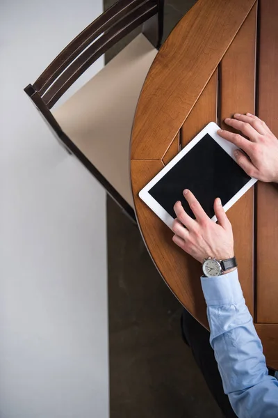 Cropped image of man using tablet and sitting at table — Stock Photo