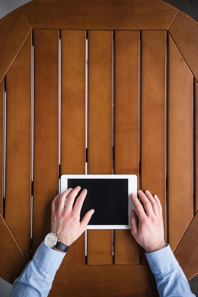 Cropped image of man using tablet and sitting at table — Stock Photo