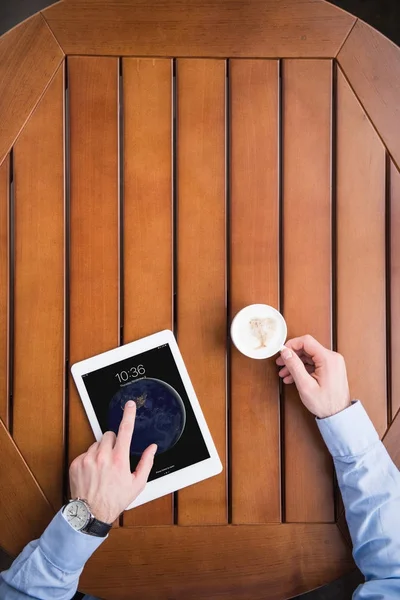 Cropped image of man sitting with coffee and ipad tablet — Stock Photo
