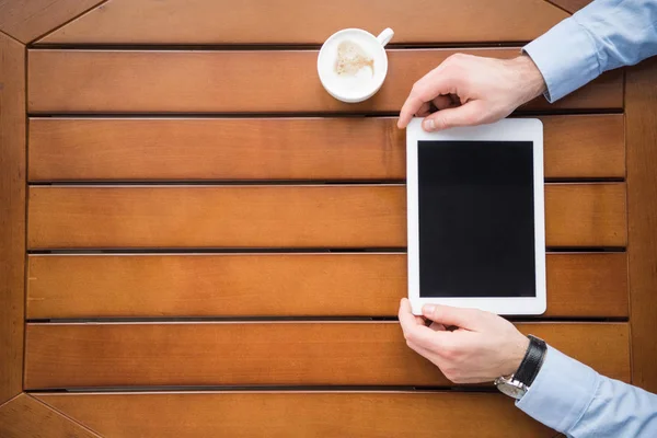 Cropped image of man holding table and sitting at table — Stock Photo