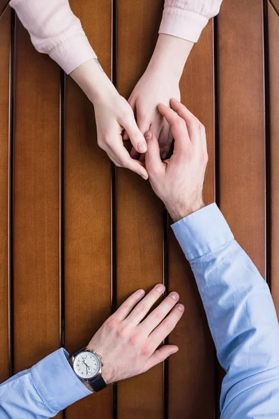 Image recadrée de l'homme palming main sur les mains copines — Photo de stock