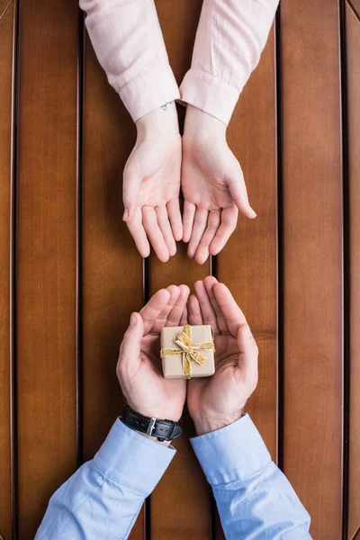 Imagen recortada de novio regalando caja de regalo a la novia - foto de stock