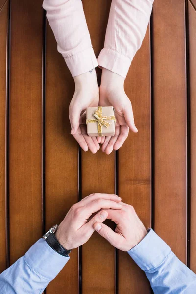 Abgeschnittenes Bild der Freundin, die ihrem Freund eine Geschenkbox schenkt — Stockfoto