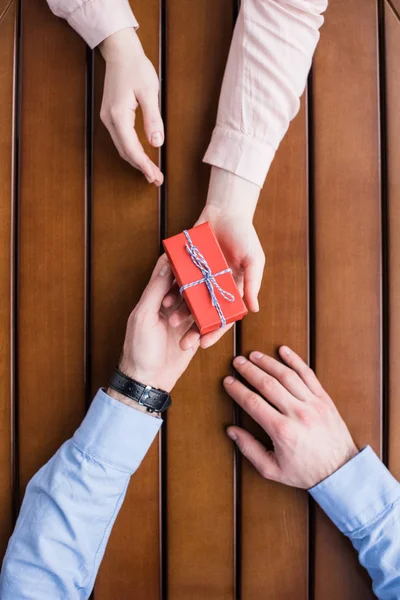 Cropped image of girlfriend gifting present box to boyfriend — Stock Photo