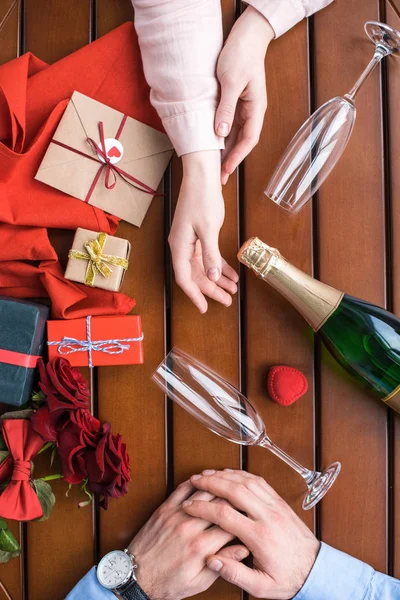 Abgeschnittenes Bild eines Paares, das mit Champagner am Tisch sitzt — Stockfoto