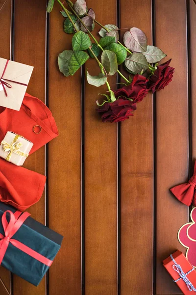 Top view of bouquet of red roses and presents on table — Stock Photo