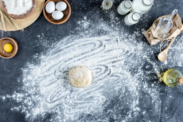 Top view of raw dough, baking ingredients and cutlery on marble surface — Stock Photo