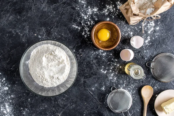 Vista dall'alto di pentole disposte e ingredienti per la cottura del pane sulla superficie di marmo scuro — Foto stock