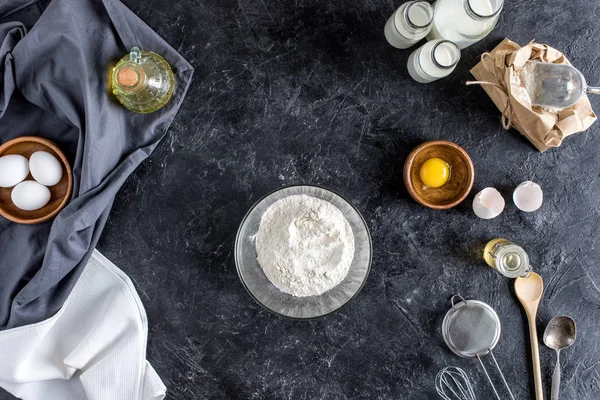 Vue de dessus des ustensiles de cuisine aménagés et des ingrédients pour la cuisson du pain sur une surface en marbre foncé — Photo de stock