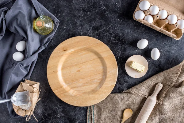 Flat lay with various ingredients for bread baking and cutlery on dark marble surface — Stock Photo
