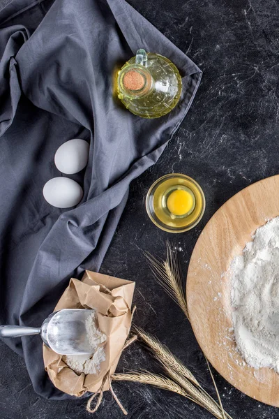 Posa piatta con vari ingredienti per la cottura del pane e posate su superficie di marmo scuro — Foto stock