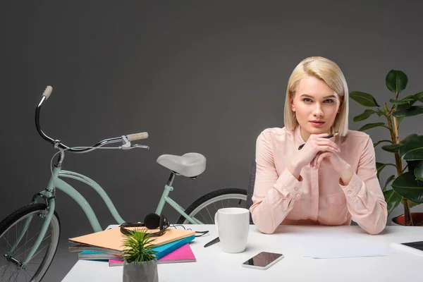 Portrait de femme d'affaires coûteuse sur le lieu de travail avec documents, smartphone et tasse de café — Photo de stock