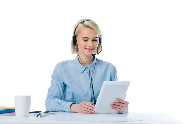 Retrato del operador de centro de llamadas joven en auriculares usando tableta en el lugar de trabajo aislado en blanco - foto de stock