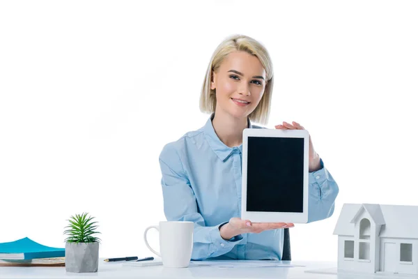 Retrato de agente de bienes raíces sonriente mostrando tableta en el lugar de trabajo aislado en blanco - foto de stock