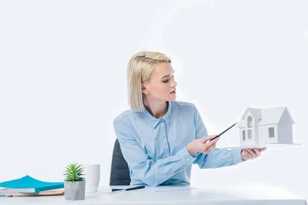 Portrait de l'agent immobilier montrant le modèle de maison en main sur le lieu de travail — Photo de stock