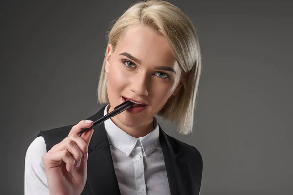 Портрет красивої молодої бізнес-леді з ручкою ізольовані на сірому — стокове фото