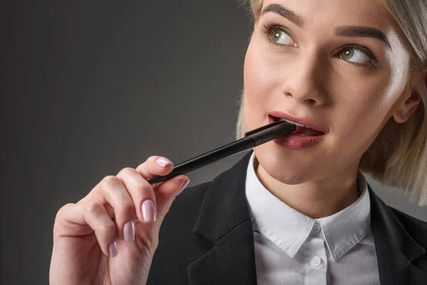 Retrato de hermosa joven empresaria con pluma aislada en gris - foto de stock