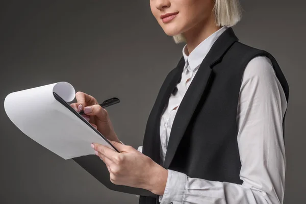 Частковий вид бізнес-леді з блокнотом ізольовано на сірому — стокове фото