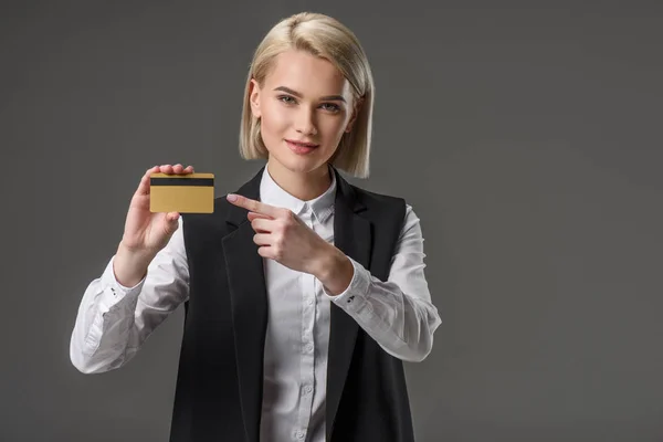 Porträt einer Frau, die auf Kreditkarte in der Hand zeigt, isoliert auf grau — Stockfoto