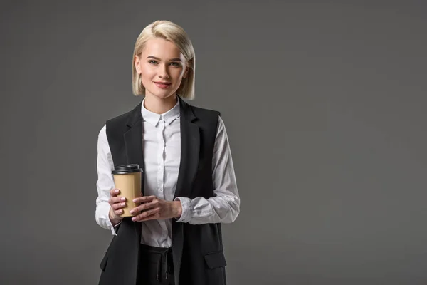 Retrato de hermosa mujer elegante con café para ir aislado en gris - foto de stock