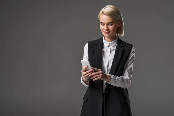 Porträt einer attraktiven Frau mit Smartphone isoliert auf grau — Stockfoto