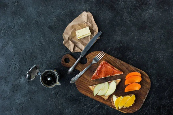 Flat lay with tasty healthy breakfast on wooden cutting board on dark tabletop — Stock Photo