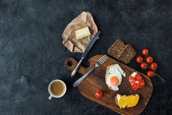 Flat lay with tasty healthy breakfast on wooden cutting board on dark tabletop — Stock Photo