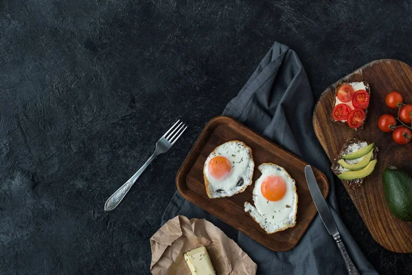 Top view of fried eggs and healthy snacks for breakfast on dark tabletop — Stock Photo