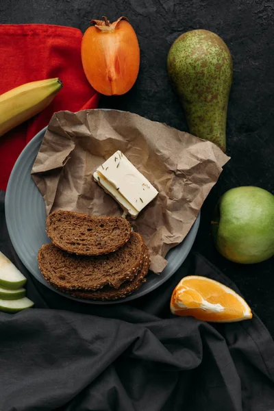 Blick von oben auf Brotscheiben, Butter und frisches Obst zum Frühstück — Stockfoto