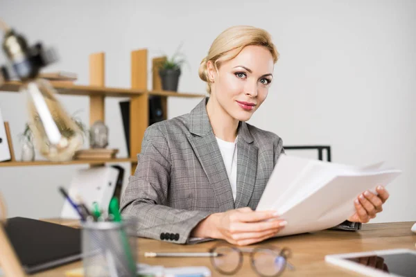 Porträt einer Geschäftsfrau, die am Arbeitsplatz im Büro Papierkram erledigt — Stockfoto