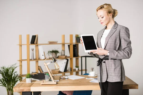 Портрет впевненої бізнес-леді з планшетом, що стоїть на робочому місці в офісі — стокове фото