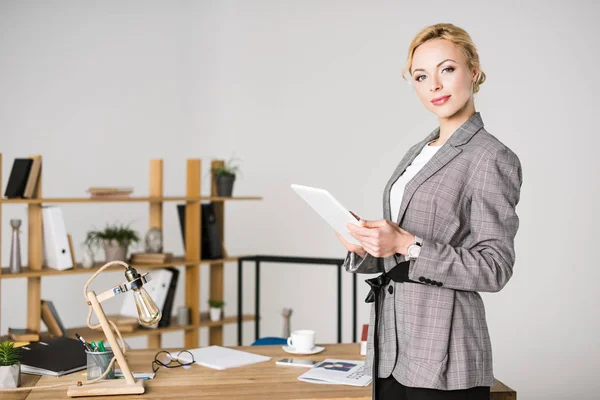 Портрет уверенной предпринимательницы с планшетом, стоящей на рабочем месте в офисе — стоковое фото