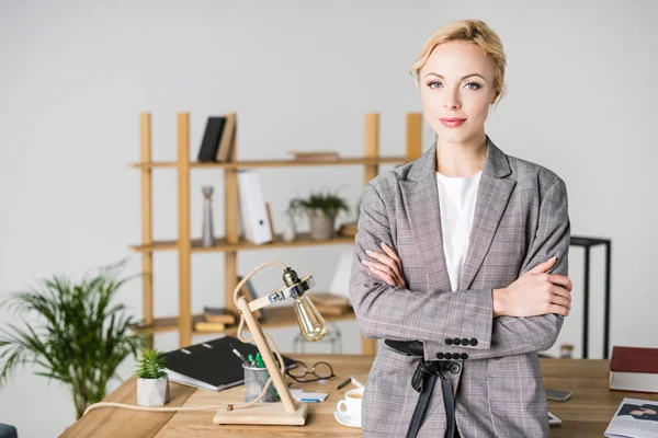 Portrait of businesswoman with arms crossed standing in office — Stock Photo