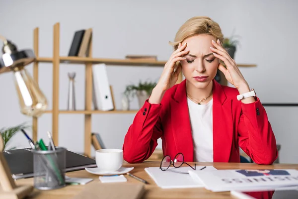 Retrato de empresária sobrecarregada sentada no local de trabalho no escritório — Fotografia de Stock