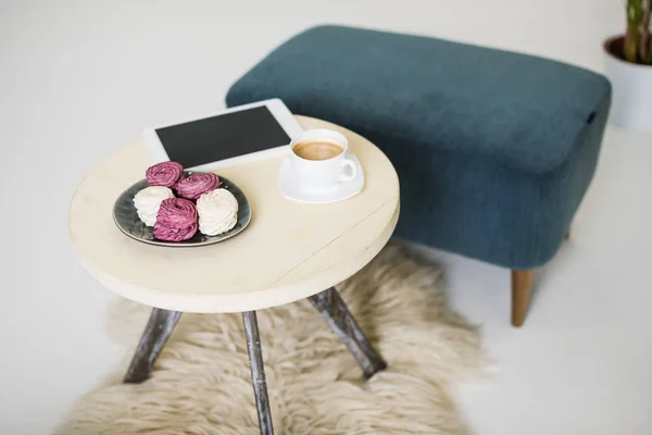 Vue rapprochée de la tablette avec écran blanc, tasse de café et zéphyr sur la table basse — Photo de stock