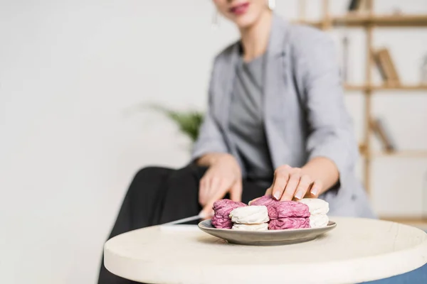 Вибірковий фокус бізнес-леді, беручи зефір з тарілки в офісі — Stock Photo