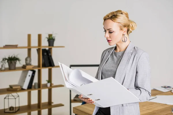 Portrait of attractive businesswoman with folder in office — Stock Photo