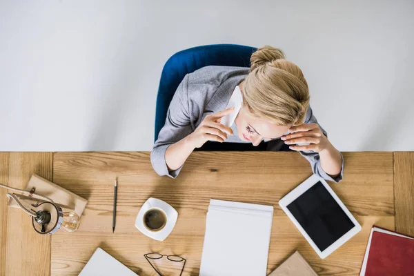 Visão geral da mulher de negócios falando no smartphone no local de trabalho no escritório — Fotografia de Stock