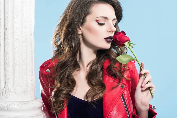 Attraente ragazza annusare rosa rossa isolato su blu, concetto di giorno di San Valentino — Foto stock