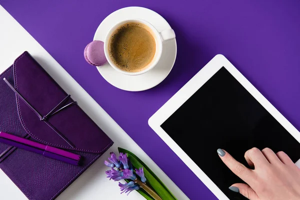 Image recadrée de la femme utilisant un comprimé à la table blanche et violette — Photo de stock