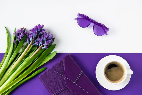 Top view of bouquet of purple hyacinth flowers and cup of coffee on table — Stock Photo