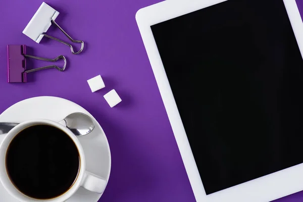 Vista superior do espaço de trabalho roxo com xícara de café e tablet — Fotografia de Stock