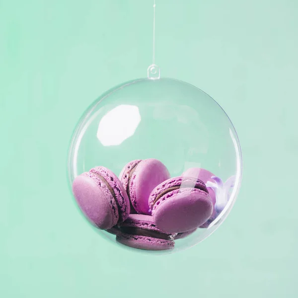 Macarons in palla di vetro appeso su sfondo turchese — Foto stock